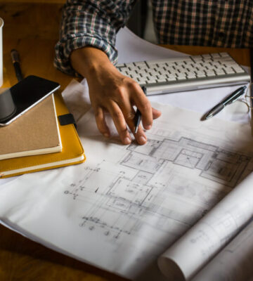 Creative architect projecting on the big drawings in the dark lo